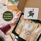 person holding a holiday gift box with three bags of oatmeal